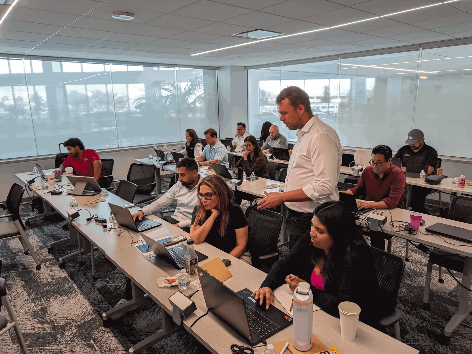 Spotless Brands' AI team working on laptops as a General Purpose instructor helps attendees during a Mastering Claude workshop